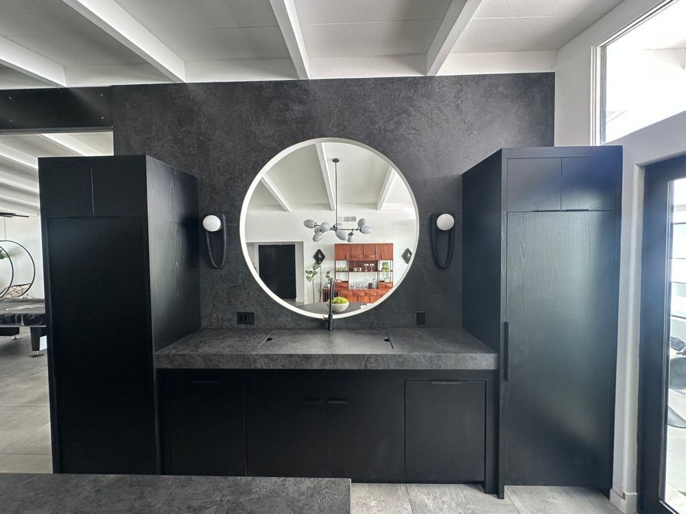 Parallel Lux black wood-grain cabinetry with a circular wall cut-out and black slab wall